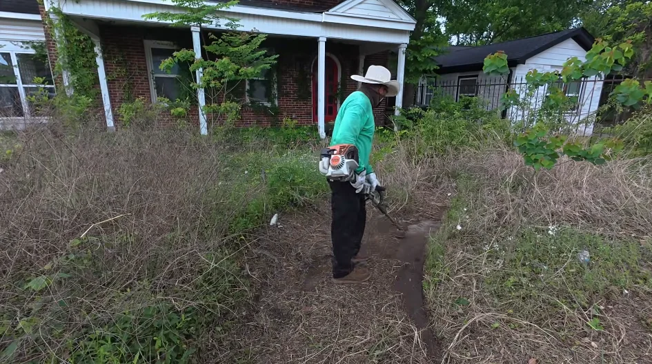 aiken lawn care landscaping work — crew member with backpack blower clearing debris during Aiken SC yard restoration